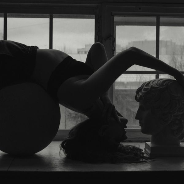 Person holding a powerful yoga pose against a dark background.